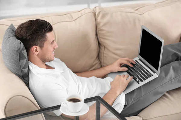 Pohledný Muž Přenosném Počítači Při Odpočinku Pohovce Doma — Stock fotografie
