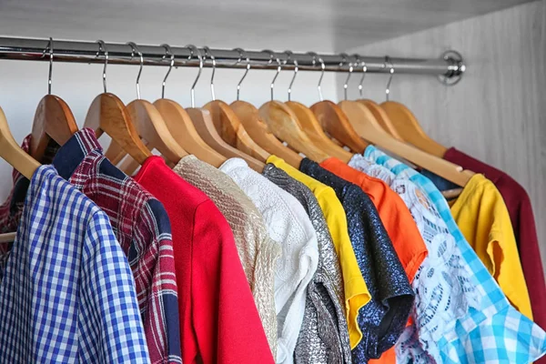 Πολύχρωμα ρούχα σε κρεμάστρες στην ντουλάπα — Φωτογραφία Αρχείου