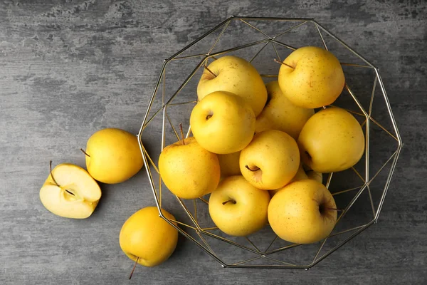 Decorative fruit bowl with ripe yellow apples on grey background, top view — Stock Photo, Image