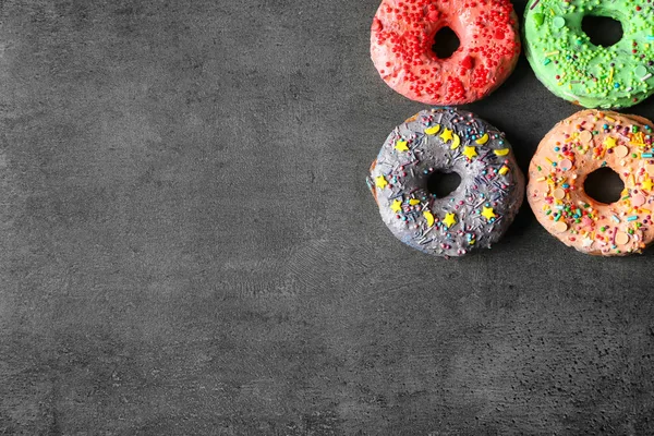 Délicieux beignets colorés frais sur fond gris — Photo