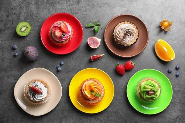Piatti con gustose torte colorate sul tavolo, vista dall'alto — Foto Stock