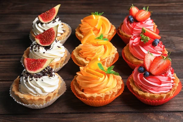 Lekker kleurrijk taarten op houten achtergrond — Stockfoto
