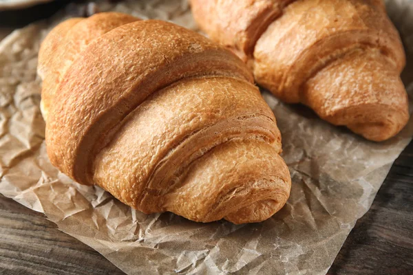 Yummy fresh croissants on wooden table — Stock Photo, Image