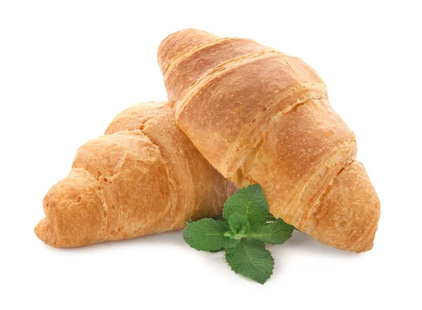 Deliziosi croissant freschi con menta su sfondo bianco — Foto Stock