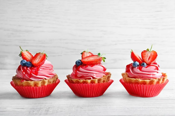 Tasty cakes on white wooden table — Stock Photo, Image