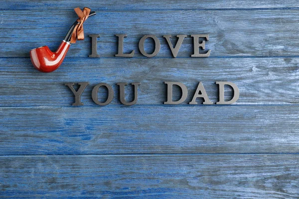 Words "I love you dad" and tobacco pipe on blue wooden background — Stock Photo, Image
