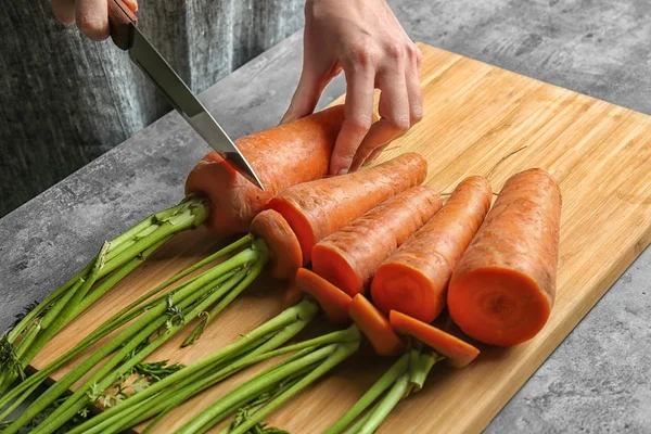 Woman cutting carrot — Stock Photo, Image