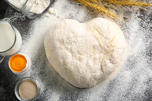 Сырое тесто, посыпанное мукой на стол
