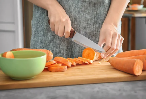 Woman cutting carrot — Stock Photo, Image