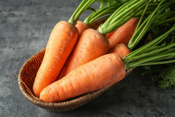 Wicker bowl with ripe carrots — Stock Photo, Image