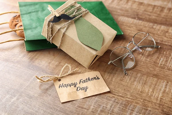 Greeting card, gifts and glasses on wooden background. Father's day composition — Stock Photo, Image
