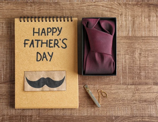 Necktie and notebook on wooden background. Father's day composition — Stock Photo, Image