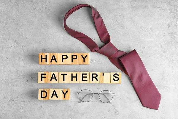 Houten kubussen, stropdas en bril op lichte achtergrond. Vaderdag samenstelling — Stockfoto