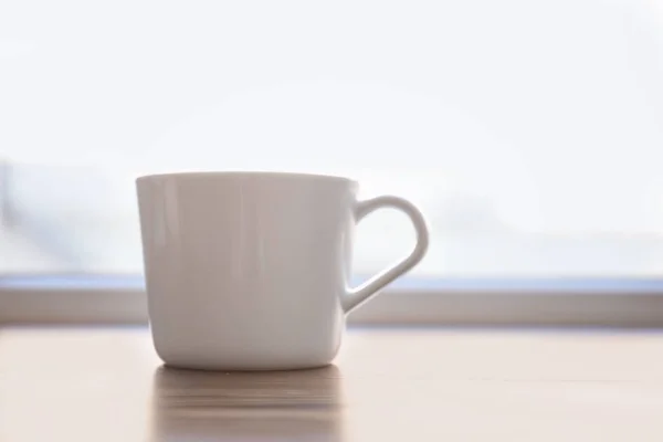 Ceramic cup on window sill — Stock Photo, Image