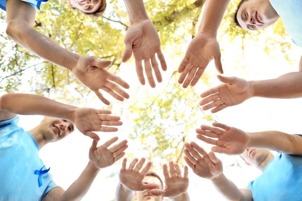 Young men in t-shirts with blue ribbons making circle with their hands outdoors. Prostate cancer awareness concept — Stock Photo, Image