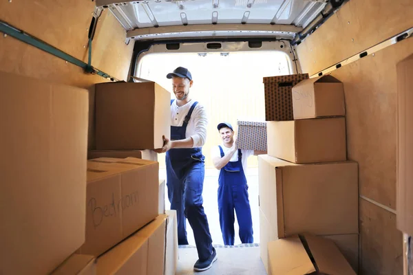 Entrega hombres descarga de cajas móviles desde el coche —  Fotos de Stock