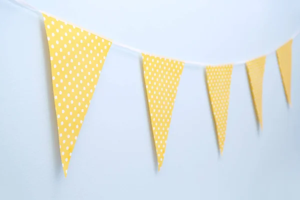 Handmade yellow garland on light wall — Stock Photo, Image