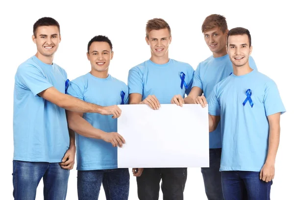 Hombres jóvenes con camisetas con cintas azules sosteniendo pancarta en blanco sobre fondo blanco. Concepto de conciencia del cáncer de próstata —  Fotos de Stock