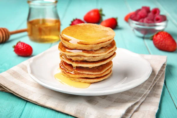 Teller mit Buchweizen-Pfannkuchen und Honig auf Holztisch — Stockfoto