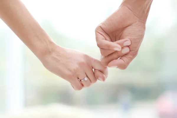 Man bedrijf verloofde van hand met verlovingsring op onscherpe achtergrond — Stockfoto