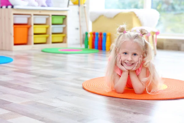 Schattig klein meisje liggend op de vloer thuis — Stockfoto