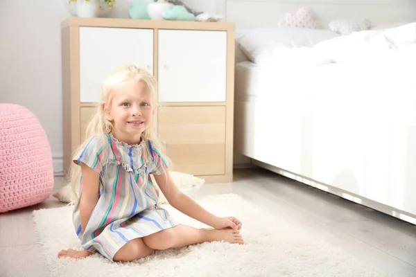 Niedliches kleines Mädchen sitzt auf dem Fußboden im Schlafzimmer — Stockfoto