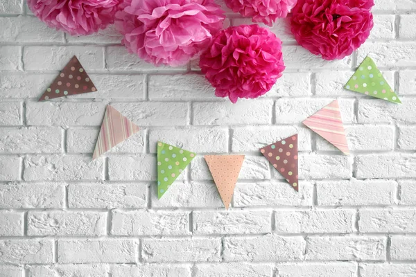 Künstliche Blumen und Girlanden für Baby-Shower-Party an weißer Ziegelwand — Stockfoto