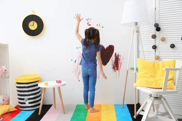 Mała dziewczynka, malowanie na ścianie w domu — Zdjęcie stockowe