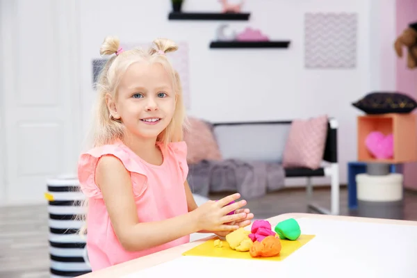 Cute little girl modeling from playdough at home — Stock Photo, Image