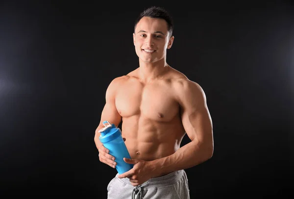 Sportif genç adam protein sallamak siyah arka plan üzerine — Stok fotoğraf