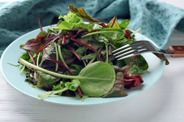 Plaka üzerinde beyaz ahşap masa, tatlı taze salata ile