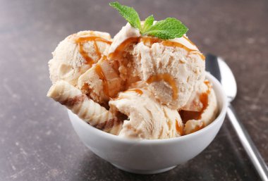 Masada bir kapta karamel tepesi ile lezzetli dondurma