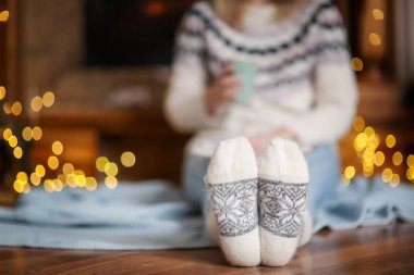 Kadın sıcak kış tatilleri için dekore edilmiş oturma odasında rahatlatıcı çorap