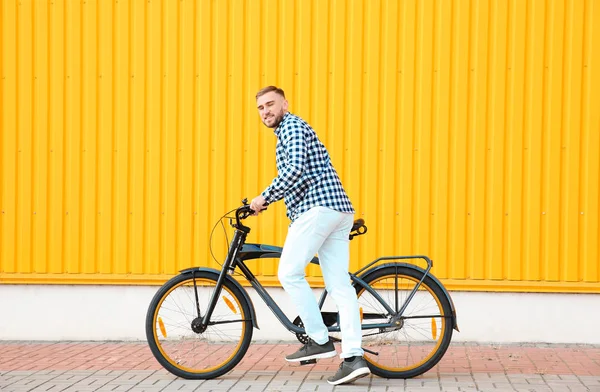 Schöner junger Hipster-Mann mit Fahrrad nahe Mauer im Freien — Stockfoto