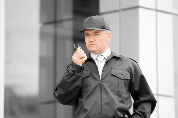 Мужчина охранник с помощью портативного радио на открытом воздухе — стоковое фото