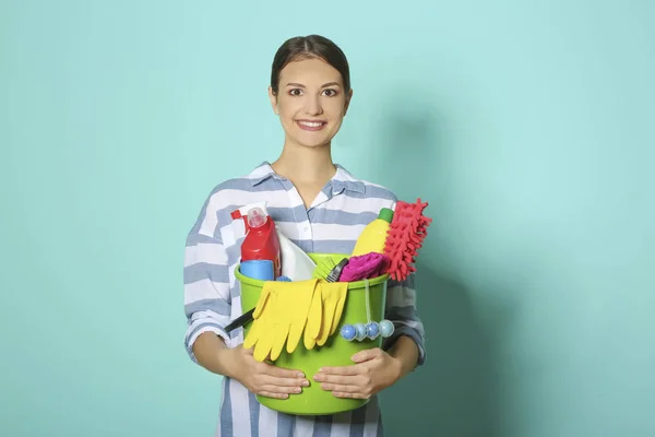 Mujer con artículos de limpieza sobre fondo de color — Foto de Stock