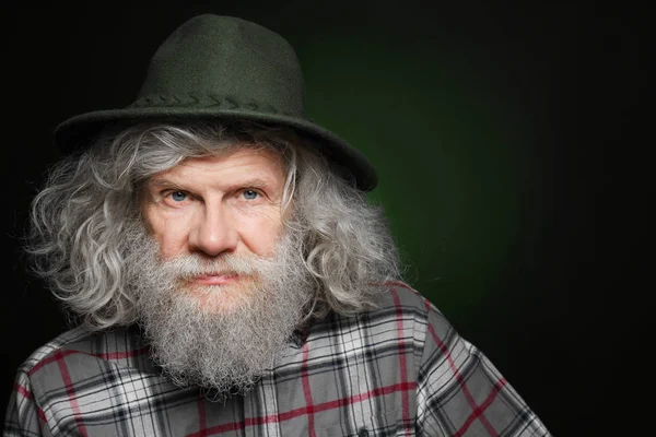 Idősebb ember kalapban a sötét háttér — Stock Fotó