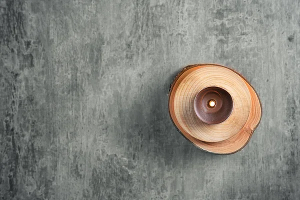 Wooden stand and burning candle on grey background — Stock Photo, Image