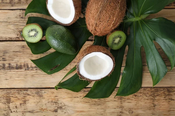 Komposition med färska kokosnötter och tropiska frukter på gröna blad — Stockfoto