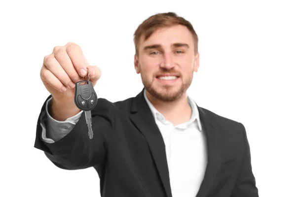 Homme en costume formel tenant la clé de voiture sur fond blanc — Photo