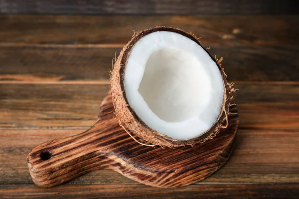De helft van een rijpe kokosnoot op houten bord — Stockfoto