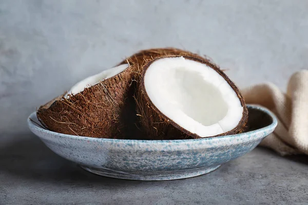 Assiette avec noix de coco fraîches sur fond gris — Photo