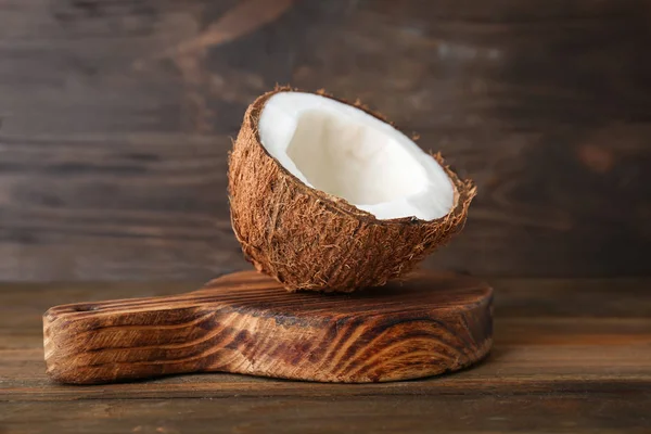 La moitié de noix de coco mûre sur une planche de bois — Photo