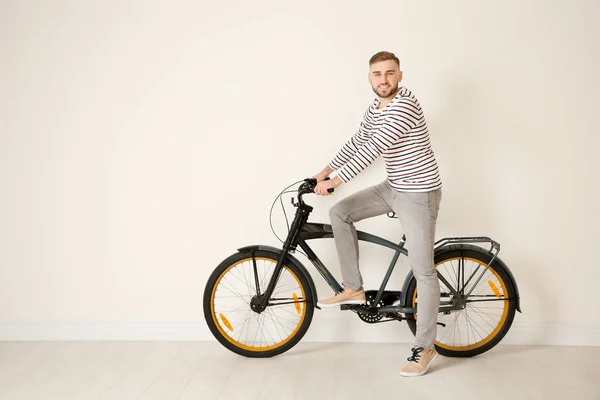 光の壁の近くの自転車を持つハンサムな若いヒップな男 — ストック写真