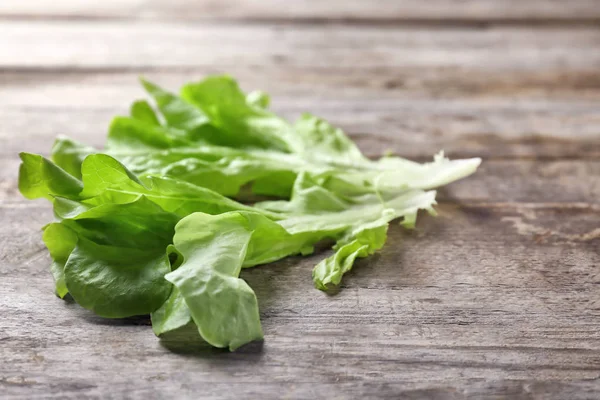 Feuilles de salade verte fraîche sur table en bois — Photo