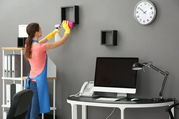 Young woman cleaning office — Stock Photo, Image