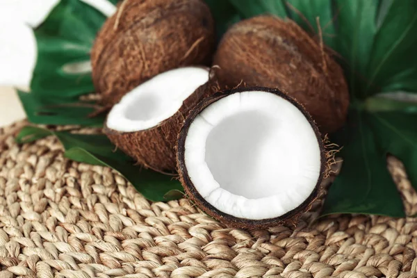 Fresh coconuts with leaf on wicker mat — Stock Photo, Image