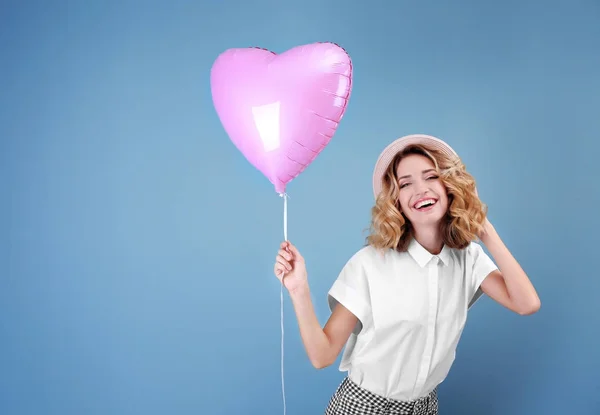 有吸引力的年轻妇女与心脏形状的空气气球在颜色背景 — 图库照片