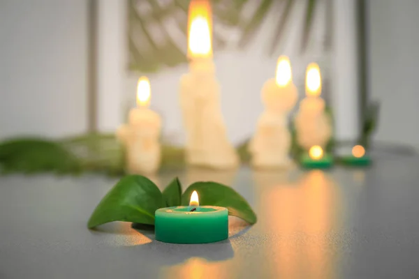 Green burning candle on table — Stock Photo, Image