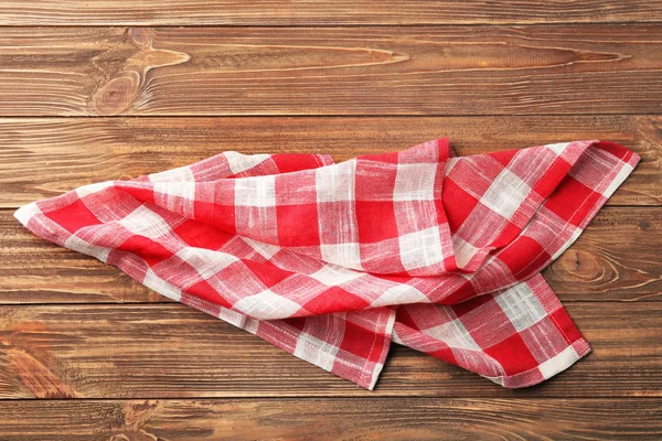 Ręcznik kuchenny kratkę na podłoże drewniane — Zdjęcie stockowe